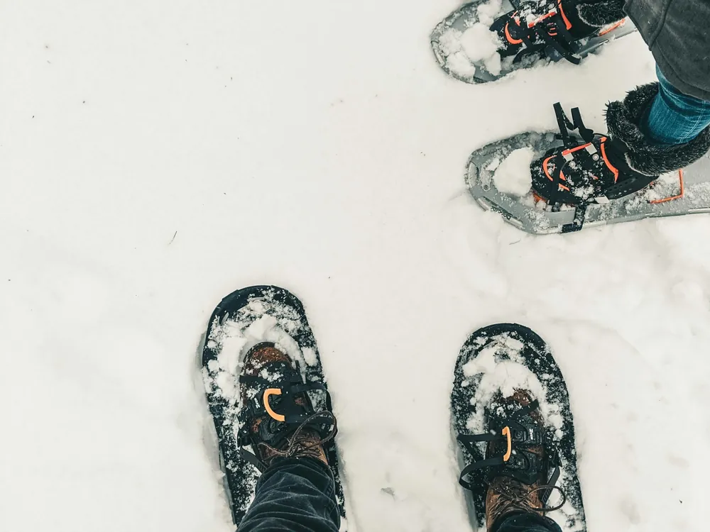 Schneeschuhe und Winterstiefel im tiefen Schnee